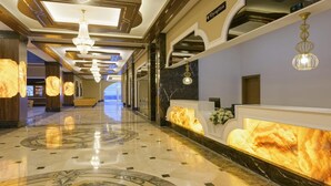 A hotel reception area with a marble floor, a reception desk, and a chandelier. - Simurg Luxury Halal Hotel (Alanya)