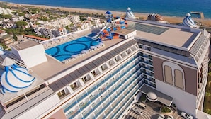 A high-rise hotel with multiple balconies, a swimming pool, and a water park. - Simurg Luxury Halal Hotel (Alanya)
