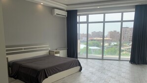A bedroom with a large bed, a radiator, and a window with curtains. - Adams Hotel (Yerevan)