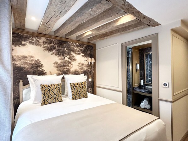 A bedroom with a bed, a wall-mounted mirror, and a wooden ceiling. - Merveil - Signature Suite - Tour Eiffel - Bourgogne (Paris)
