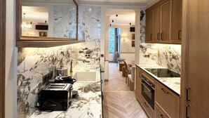 A modern kitchen with marble countertops, wooden cabinets, and a Bosch toaster. - Merveil - Signature Suite - Tour Eiffel - Bourgogne (Paris)
