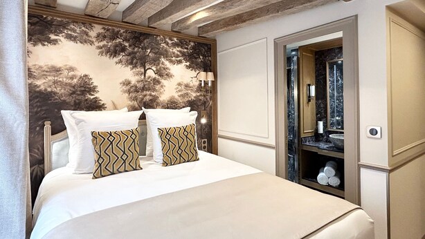 A bedroom with a bed, a wall-mounted mirror, and a wooden ceiling. - Merveil - Signature Suite - Tour Eiffel - Bourgogne (Paris)