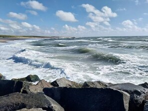 A rocky shoreline with waves crashing against the rocks. - 6 Person Holiday Home in Skaerbaek (Skaerbaek)