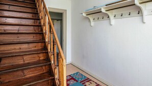 A wooden staircase leading to a room with a white wall and a patterned rug. - 6 Person Holiday Home in Skaerbaek (Skaerbaek)