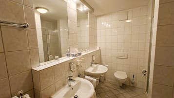 Un baño moderno con dos lavamanos, inodoro y ducha.