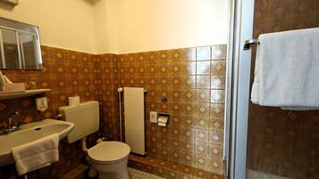 A bathroom with a toilet, sink, and towel rack.