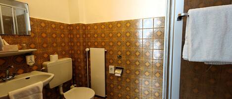 Een badkamer met toilet, wastafel en handdoekhouder.