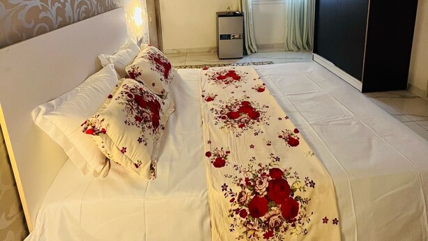 A hotel room with a large bed, a wardrobe, a desk, and a window with curtains. - ROOM WITH INDOOR WELLNESS (Dakar)