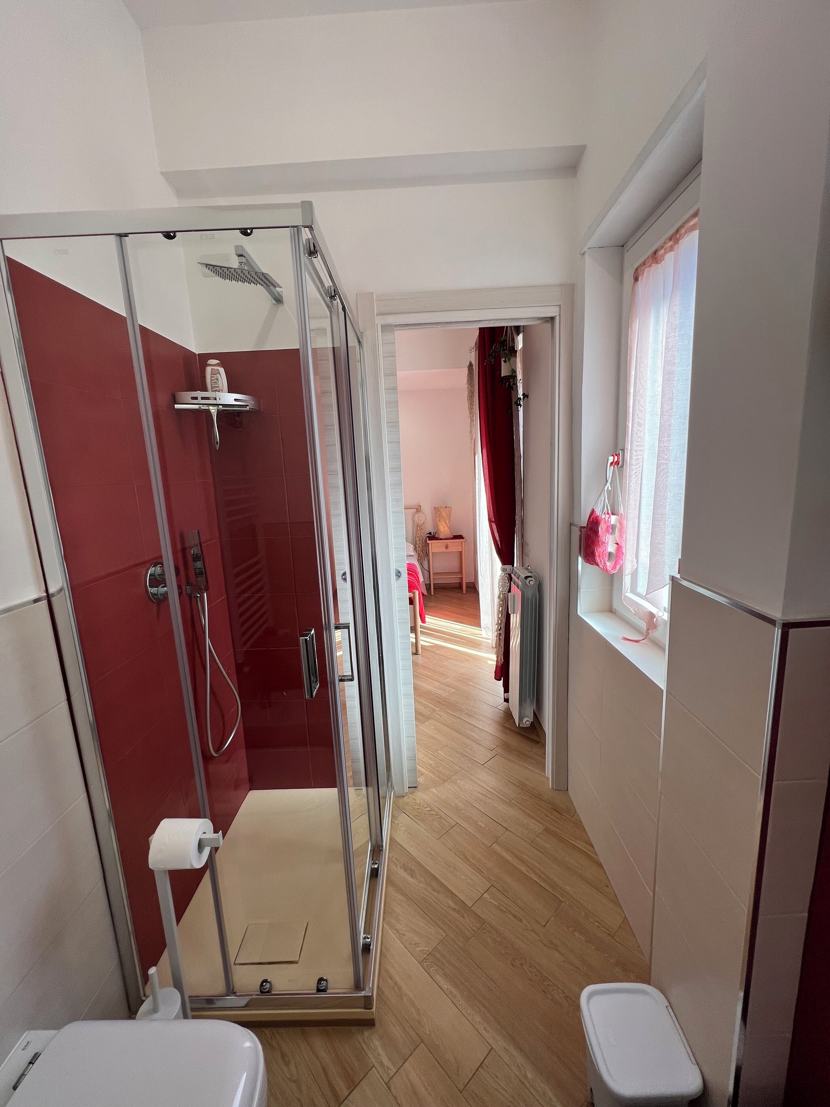 A modern bathroom with a glass-enclosed shower, a toilet, and a sink.