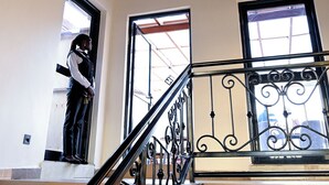 A wooden ceiling with a hanging light fixture and a staircase with wrought iron railings. - Neon Hotel Ntinda (Kampala)