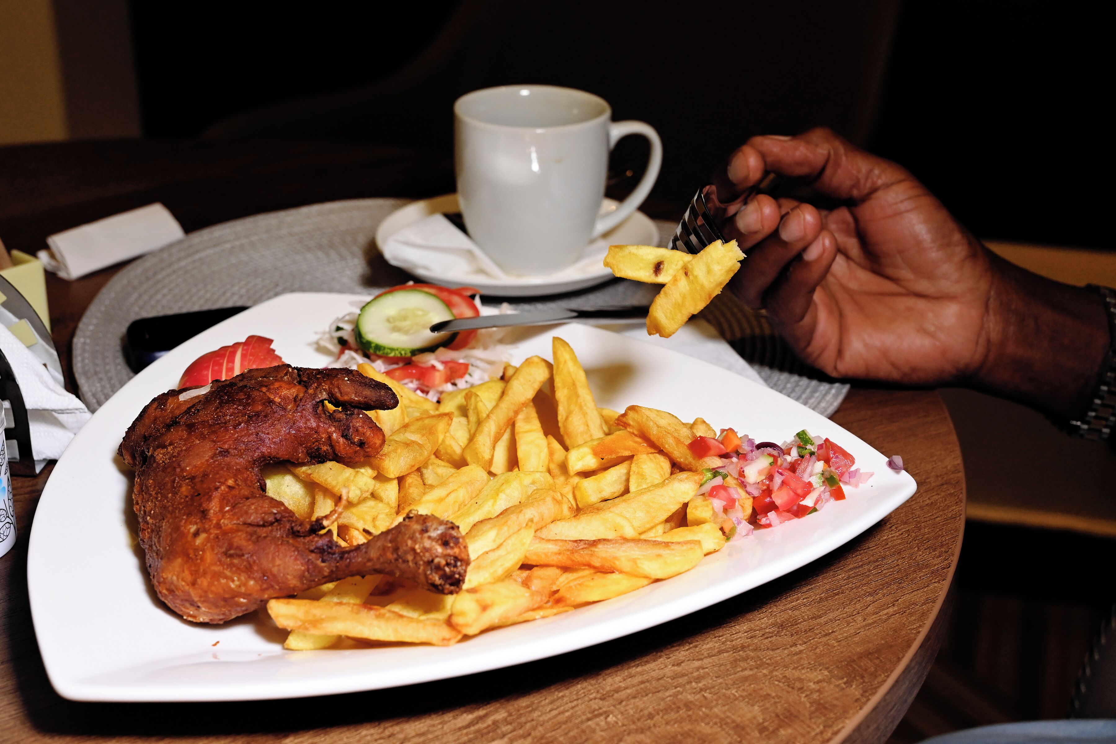Une assiette comprenant un morceau de poulet rôti, des frites et une salade.