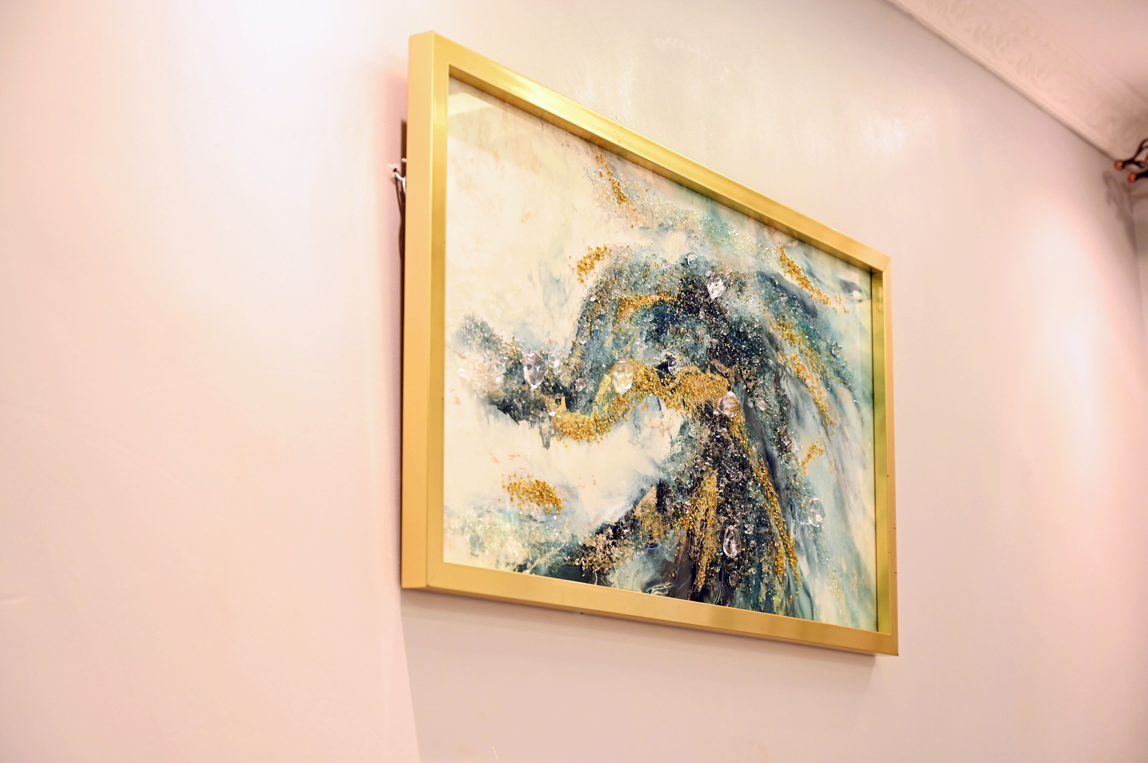 Een abstract schilderij in een lijst aan de muur.