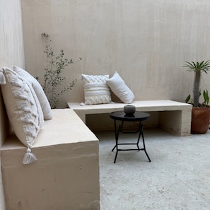 Relax in a serene outdoor space with a low bench and a small table.