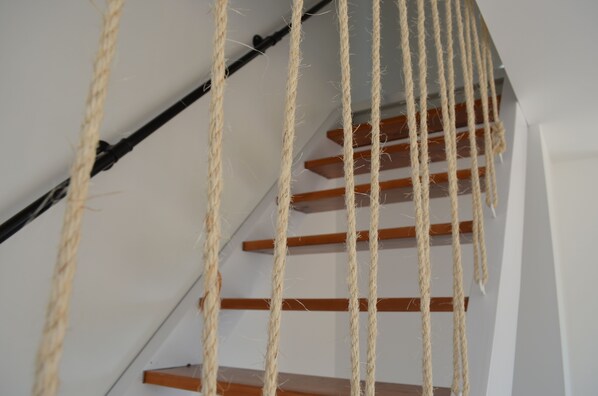 A staircase with wooden steps and a black handrail.