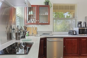 Una cocina moderna con electrodomésticos de acero inoxidable, armarios de madera y un lavavajillas empotrado.