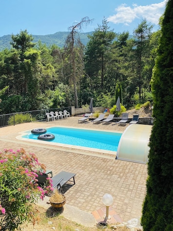 piscine avec son abris télescopique, ses transats et parasols