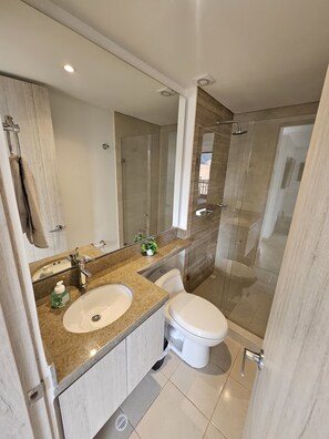 Chuveiro, toalhas de banho, sabonete, papel higiênico