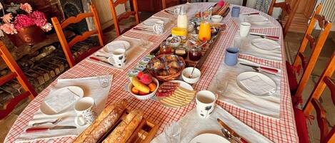 A dining table set with a checkered tablecloth, various dishes, bread, and utensils.