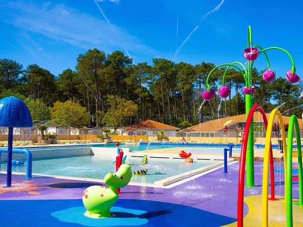 Un parque acuático con piscina, toboganes y estructuras de juego coloridas.