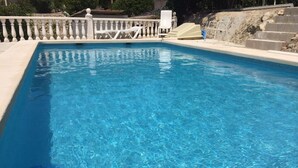 A clear blue swimming pool with a tiled edge, a white balustrade, and a set of stairs leading up to a higher level. - Villa with private pool, terrace, in Benissa, CostaBlanca, to rent 7 days  (VC)
