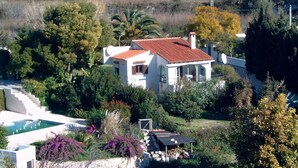 A white house with a red-tiled roof, surrounded by lush greenery and a swimming pool. - Villa with private pool, terrace, in Benissa, CostaBlanca, to rent 7 days  (VC)