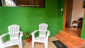 Two white plastic chairs, a potted plant, and a black doormat with "WELCOME" written on it, leading to a tiled staircase. - Bed & Breakfast 15 minutes from La Fortuna, Ideal to relax and unwind! (Provincia de Alajuela)