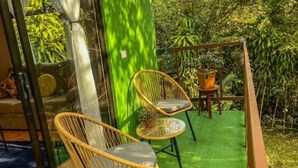 A balcony with two wicker chairs, a small table, and a potted plant. - Bed & Breakfast 15 minutes from La Fortuna, Ideal to relax and unwind! (Provincia de Alajuela)