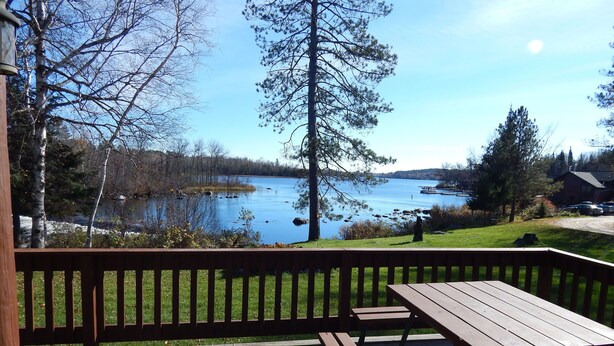 A wooden deck with a picnic table overlooking a lake. - Aerie - Vermilion Dam Lodge (Orr)