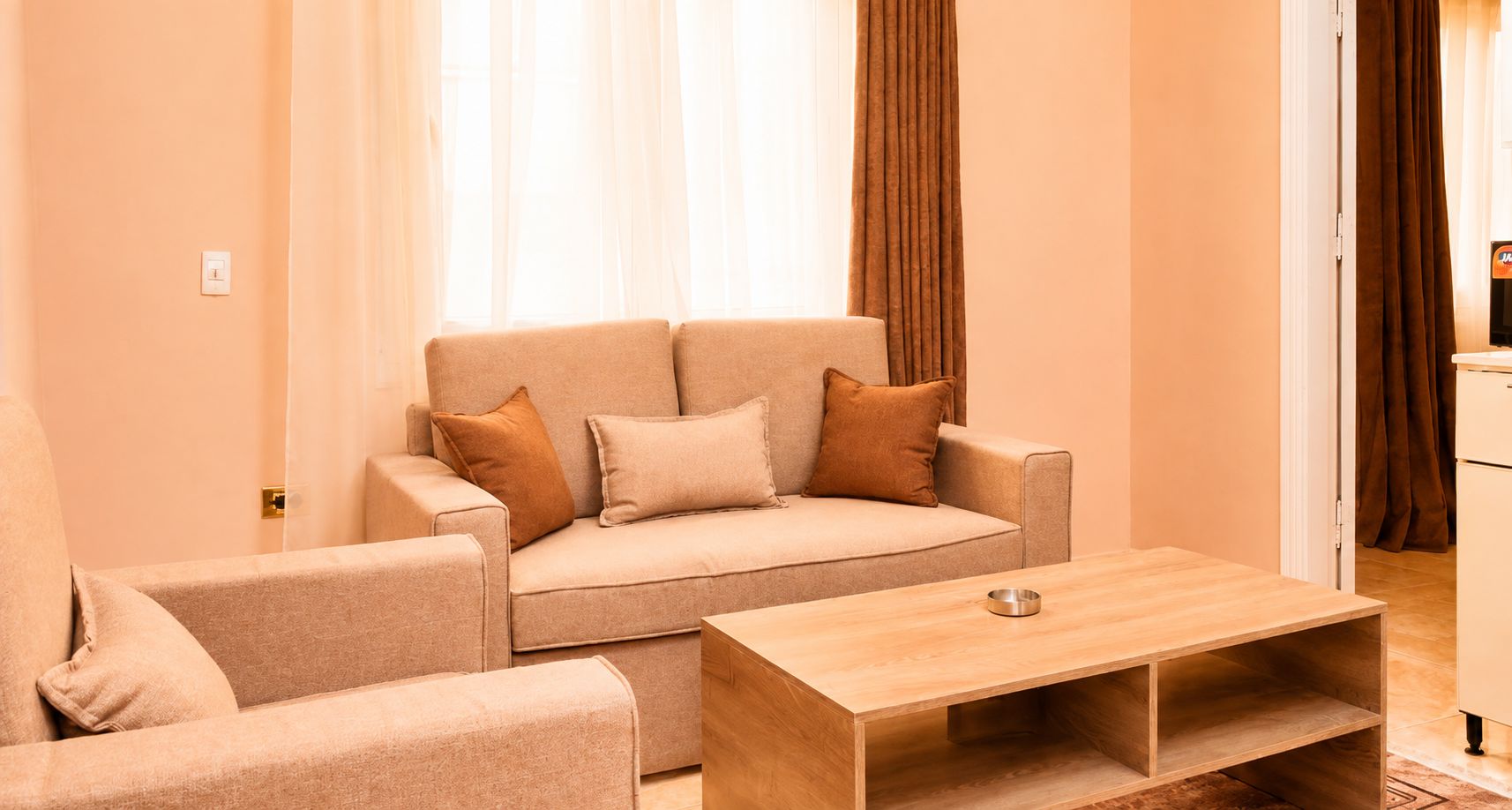 A living room with a sofa, armchair, and a wooden coffee table.