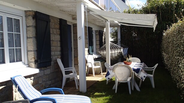 A patio with white chairs and a table, a hanging chair, and a pergola. - 54 m2 apartment 150m from the sea (main beach) and 100m from the village (Damgan)