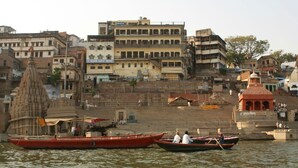 Vista al río con barcos, un templo y edificios de varios pisos.