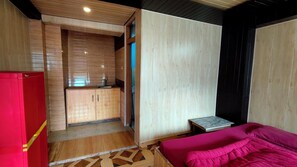 A compact room with a kitchenette, a bed, and a small table. - Bodh Niwas - Unit of Nest Community (Manali)