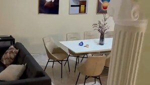 A living room with a dark sofa, a dining table with chairs, and a white column. - 4-bedroom luxury villa in tranquil Puerto Plata with WiFi, AC stunning rooftop (Puerto Plata)