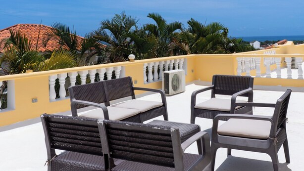 A rooftop terrace with outdoor furniture, a clear sky, and a view of the sea. - 4-bedroom luxury villa in tranquil Puerto Plata with WiFi, AC stunning rooftop (Puerto Plata)