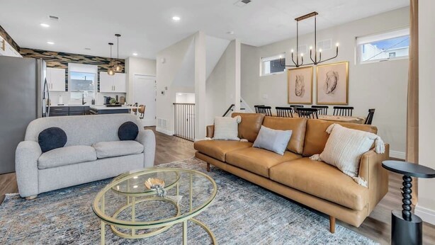 Een moderne woonkamer met een bank, salontafel en een eethoek.