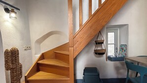 A wooden staircase leading to a room with a window, a small table, and a chair. - Pretty house in the historic district of Cahors close to shops (Cahors)