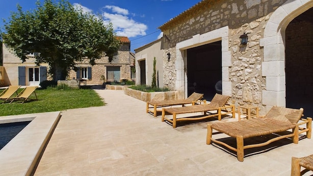 A stone building with outdoor seating and a pool area. - Mas Sainte Croix - Authentic renovated farmhouse in Provence with swimming pool (Fontvieille)