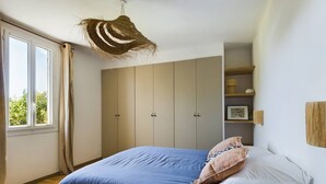 A bedroom with a bed, wardrobe, and a hanging light fixture. - Mas Sainte Croix - Authentic renovated farmhouse in Provence with swimming pool (Fontvieille)