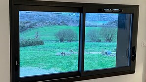 Et vægmonteret TV, der viser et landskab med bløde bakker og sparsom beplantning.