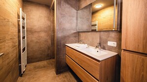 A modern bathroom with wooden walls, a large mirror, and a double sink. - 3-bedroom apartment Frauenschuh 2-10 pers (110m2), terrace & view of the slopes (Berwang)