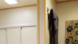 A bathroom with a glass-enclosed shower, a toilet, and a towel rack with towels.