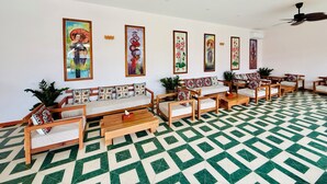 A room with a patterned floor, wooden furniture, and wall-mounted artwork.