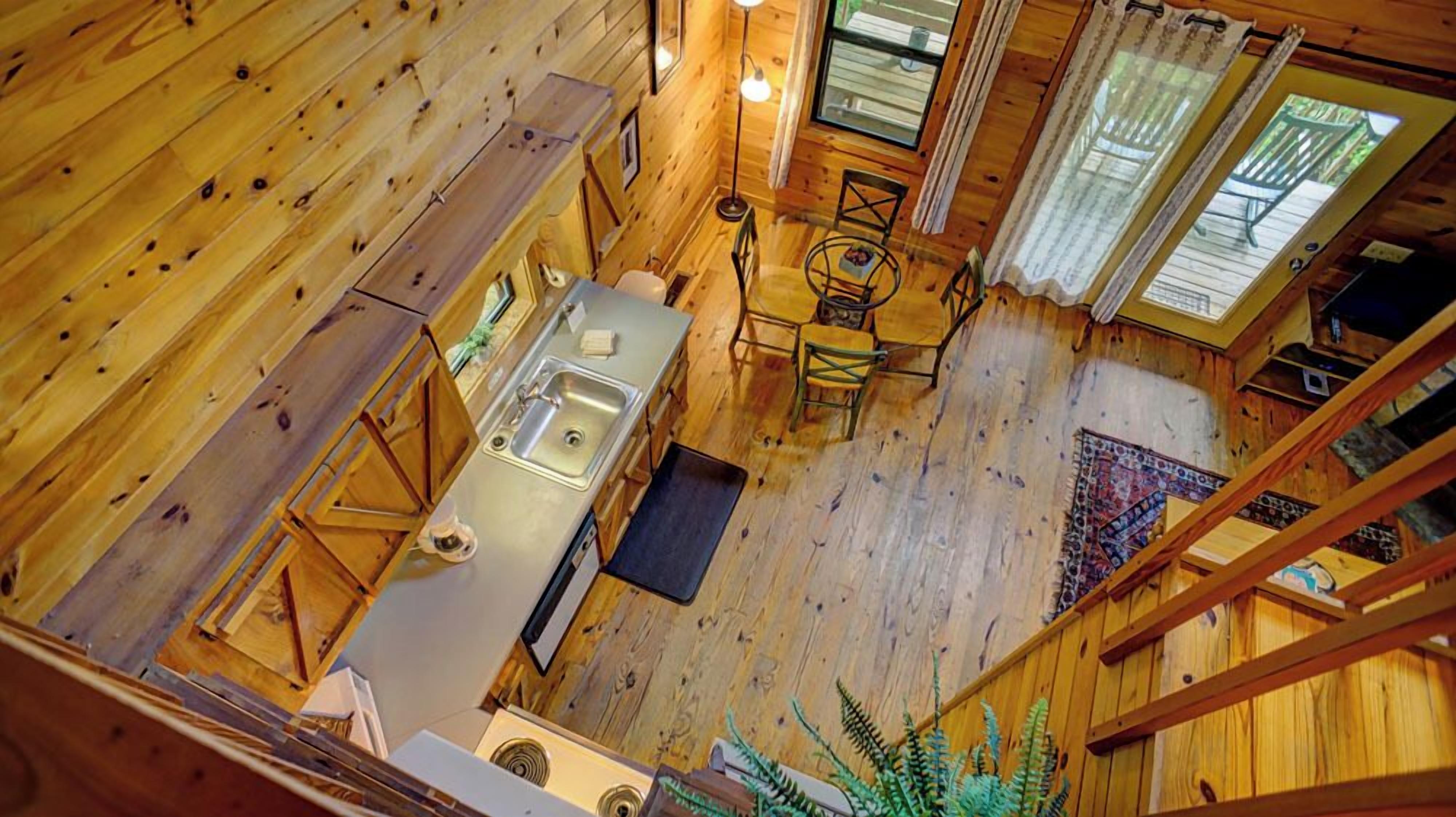 A cabin with a kitchen, dining area, and a large window.