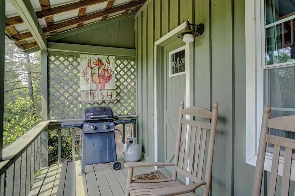 A wooden porch with a grill, a chair, and a sign reading "9FISH".