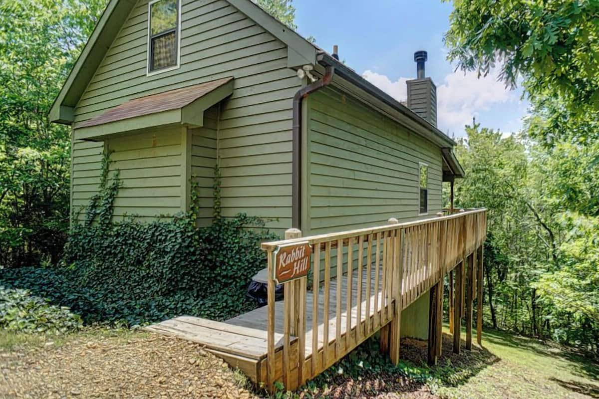 A house with a wooden deck and a sign that reads "Rabbit Hill."