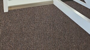 Un modèle d’escalier moderne, de couleur blanche, doté d’un motif géométrique et menant à un niveau supérieur aux tons sombres.