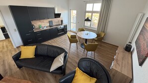 Ein modernes Apartment mit Küche, Essbereich und Wohnzimmer.