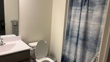 Een douche, handdoeken, zeep, toiletpapier