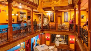 Un hall de hotel de varios niveles con elaborada carpintería, una escalera central y una exhibición temática de Star Wars.