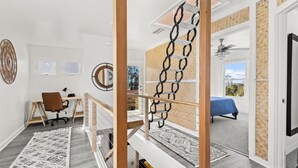 Un dormitorio moderno con escritorio, silla y cama con vistas.